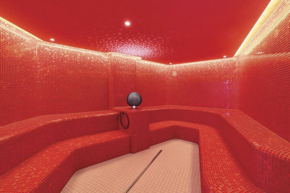 Im Dampfbad sorgt schon allein die Wandbekleidung mit dem kräftigen Rotton