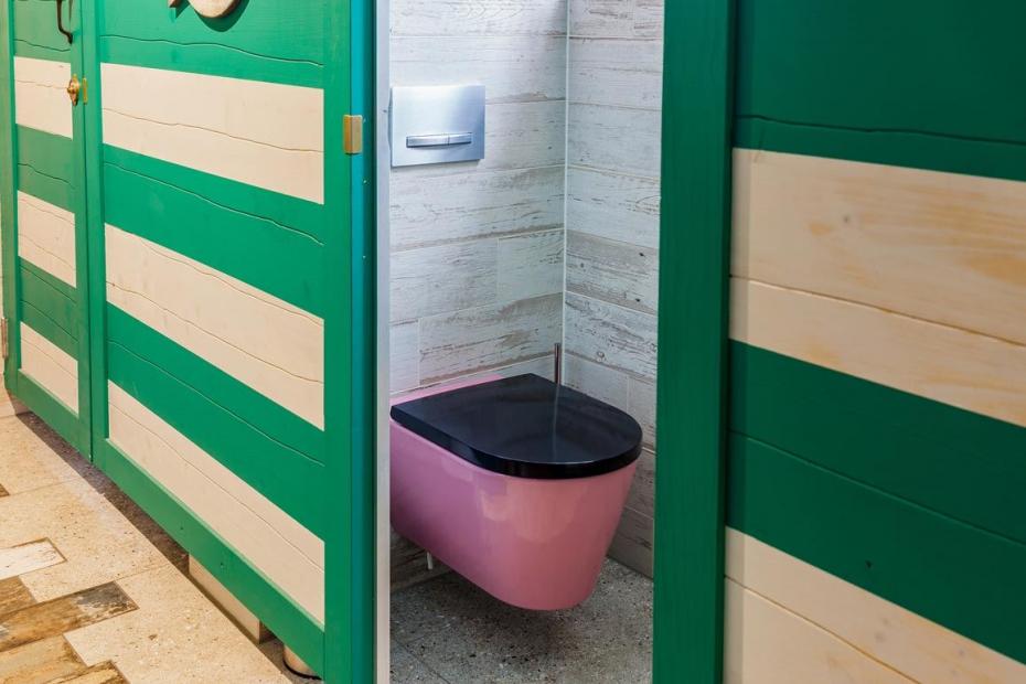 Die WC-Kabinen sind wie alte Strandumkleiden gestaltet, die pinkfarbenen WCs setzen dazu einen vergnüglichen optischen Kontrapunkt. Foto: Laufen