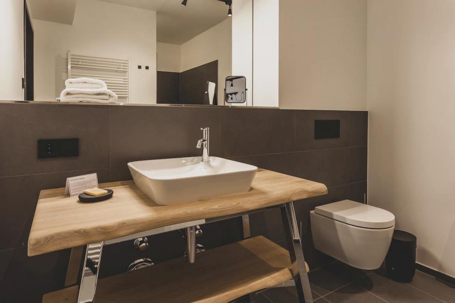 Die Badezimmer sind offen und wohnlich gestaltet, auf diesem Foto mit dem Waschplatz der Serie „Cape Cod“, der Armatur „C.1“ und dem „ME by Starck WC“ (alle Duravit AG).